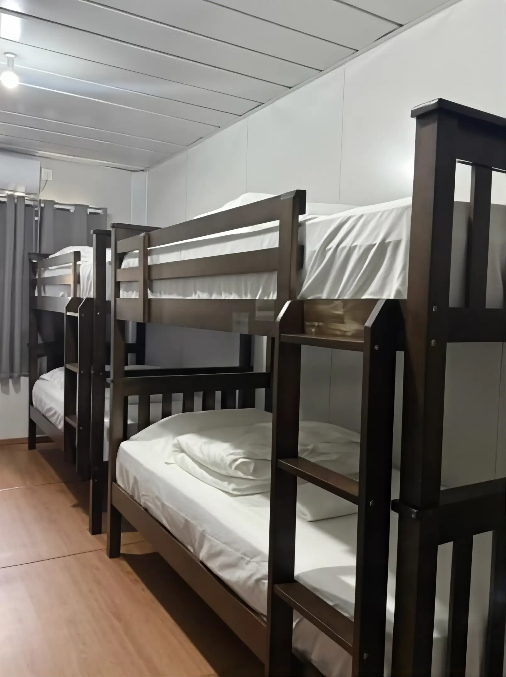 TDB Tioman Resort dorm room with wooden bunk beds and white linens